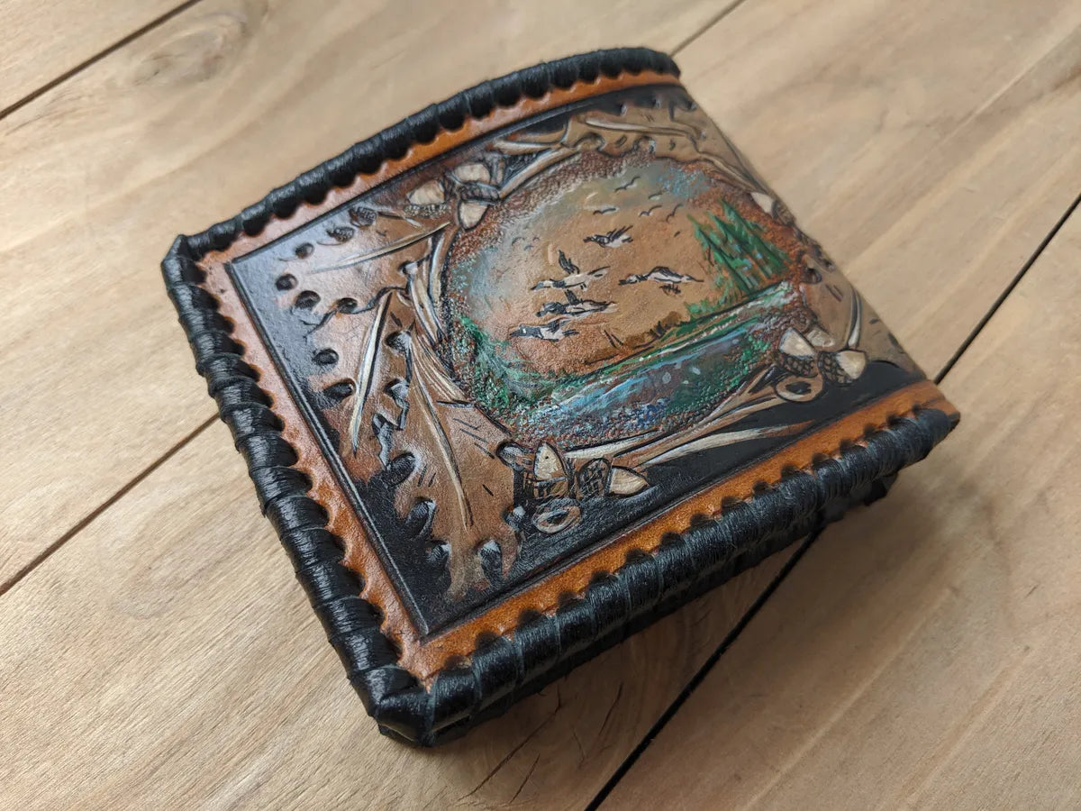 Embossed bifold leather wallet featuring goose hunting design