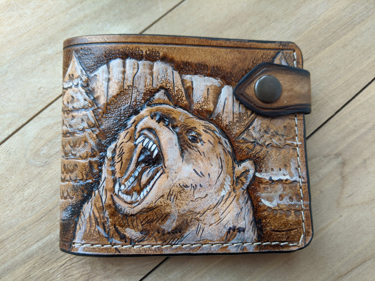 Handmade carved leather bifold wallet featuring a grizzly bear design, ideal for outdoorsmen and hunters